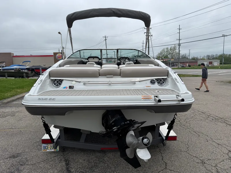 Slide: The Image of 2018 Crownline 235 SS boat, rear view, parked on pavement, overcast sky. - 1