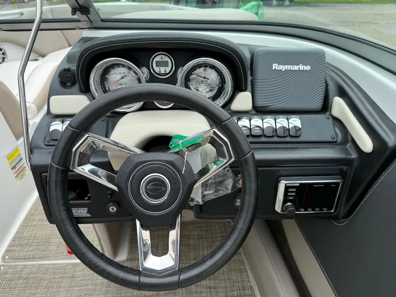 Slide: The Image of 2018 Crownline 235 SS boat dashboard with steering wheel and Raymarine navigation system. - 7