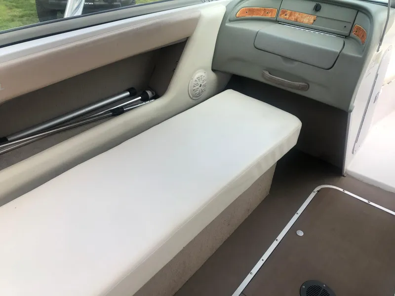 Slide: The Image of Interior seating of a 1997 Chaparral 1930 SS boat, featuring beige upholstery and storage compartments. - 8