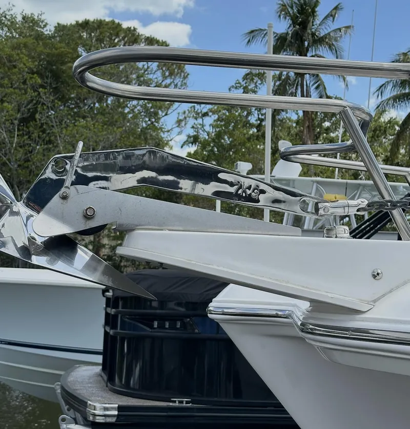 Slide: The Image of 2021 World Cat 255 DC boat with stainless steel anchor, docked near lush greenery and palm trees. - 10