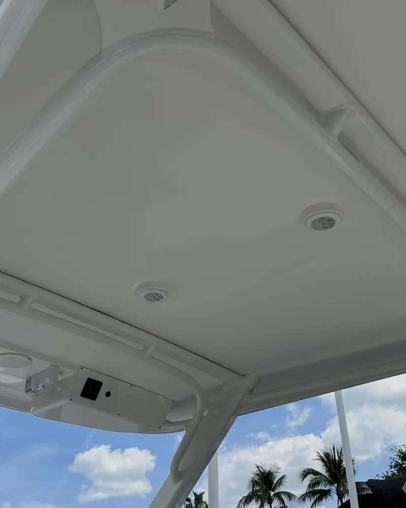 Slide: The Image of 2021 World Cat 255 DC boat canopy with integrated lights, under a clear blue sky. - 20