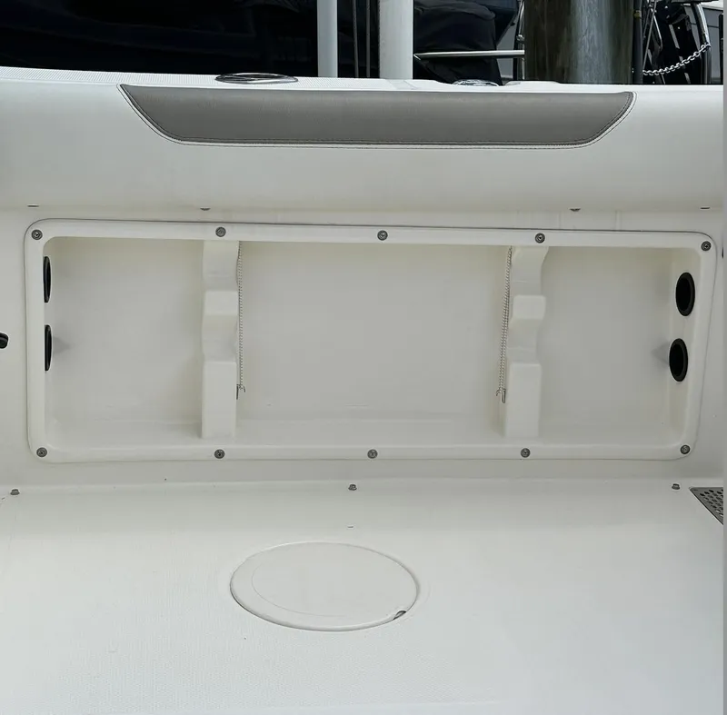 Slide: The Image of 2021 World Cat 255 DC boat interior storage compartment, white finish, open hatch. - 22