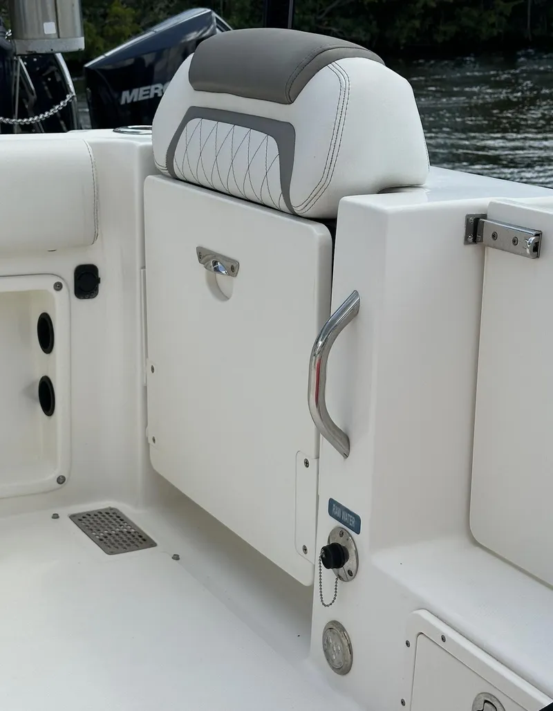 Slide: The Image of 2021 World Cat 255 DC boat interior with cushioned seating and storage compartment. - 23