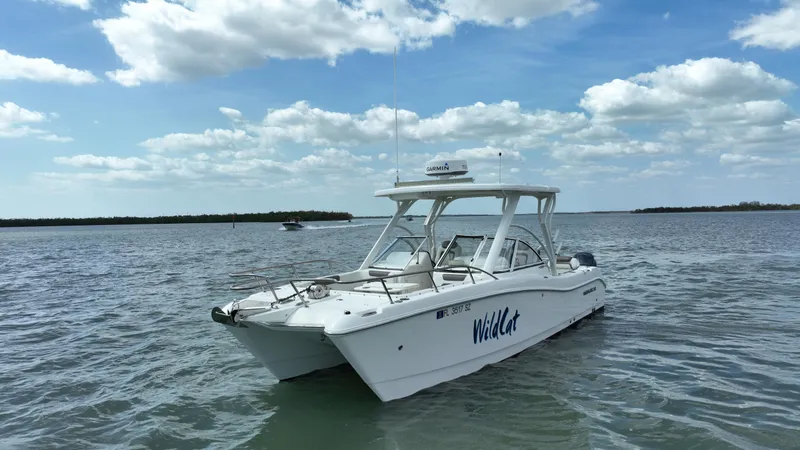 Slide: The Image of 2021 World Cat 255 DC boat on calm water under a partly cloudy sky. - 3
