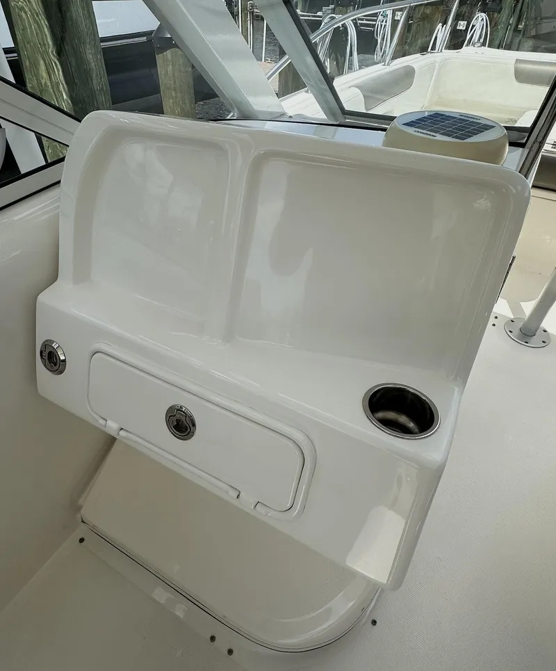 Slide: The Image of 2021 World Cat 255 DC boat interior with storage compartment and cup holder. - 34