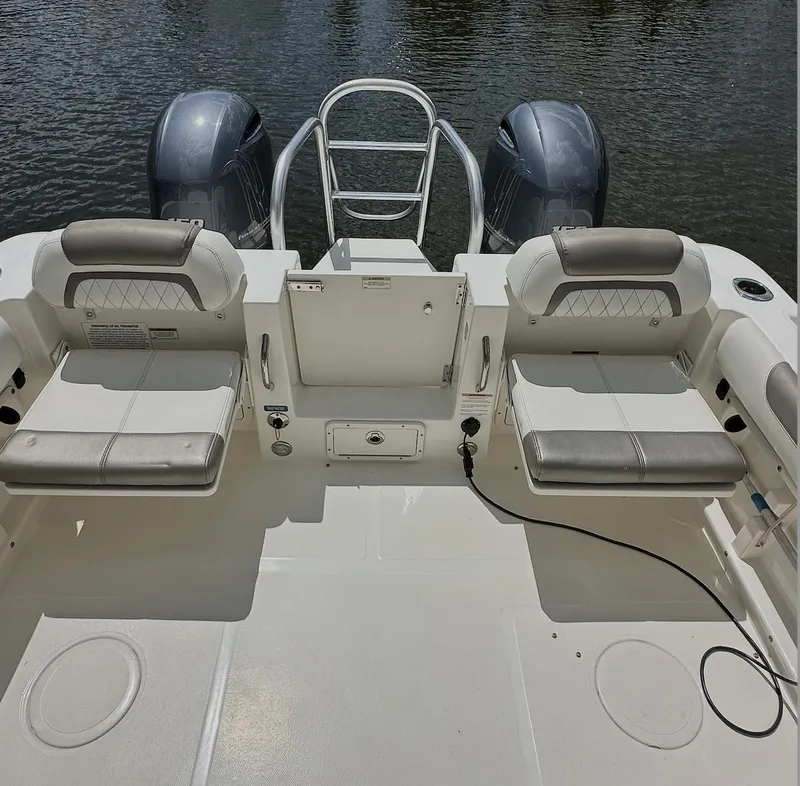 Slide: The Image of 2021 World Cat 255 DC boat interior with dual engines and seating, on calm water. - 47