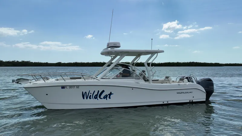 Slide: The Image of 2021 World Cat 255 DC boat named "WildCat" on calm water under a clear sky. - 5