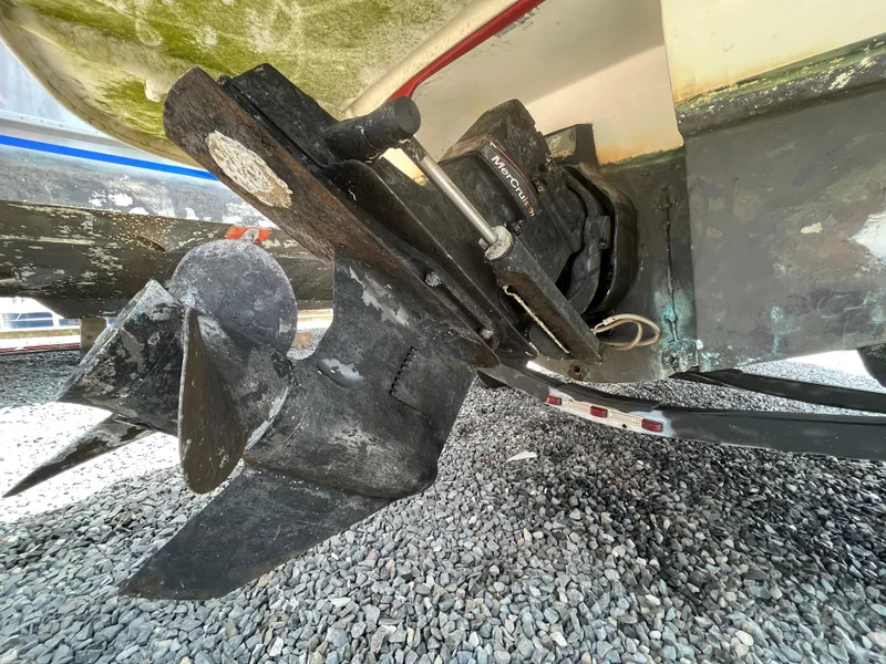 Slide: The Image of Bayliner 195 boat propeller and outdrive, 2011 model, on gravel surface. - 10