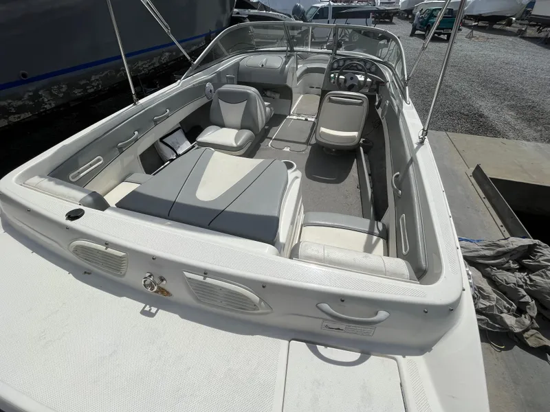 Slide: The Image of 2011 Bayliner 195 boat interior with seating and steering wheel, docked outdoors. - 11