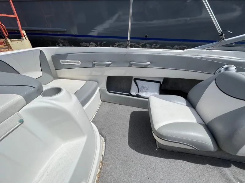 Slide: The Image of 2011 Bayliner 195 boat interior with gray seating and storage compartments. - 15