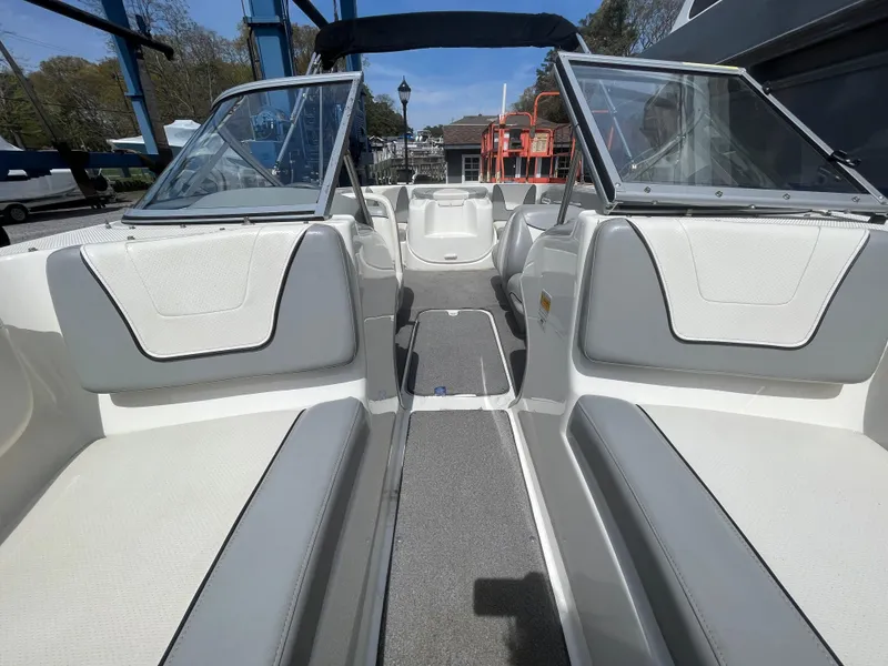 Slide: The Image of 2011 Bayliner 195 boat interior with open seating and windshield, docked outdoors. - 19