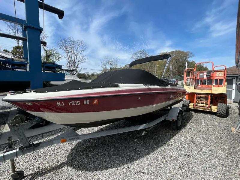 Slide: The Image of 2011 Bayliner 195 boat on trailer, parked outdoors under a clear sky. - 28