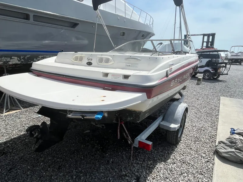 Slide: The Image of 2011 Bayliner 195 boat on trailer, parked on gravel, rear view. - 5