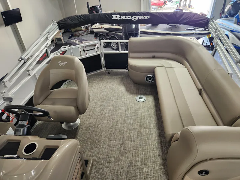 Slide: The Image of 2025 Ranger 200C boat interior with beige seating and steering console. - 14