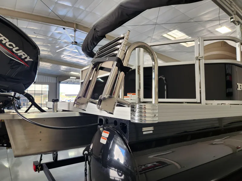 Slide: The Image of 2025 Ranger 200C boat with Mercury engine in showroom, featuring a stainless steel ladder. - 6