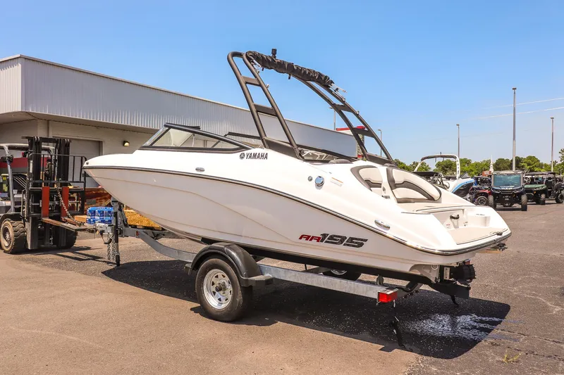 Slide: The Image of 2025 Yamaha Boats AR195 on trailer, parked outdoors under clear blue sky. - 10