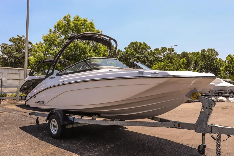 Slide: The Image of 2025 Yamaha Boats AR195 on trailer, parked outdoors, sunny day. - 14