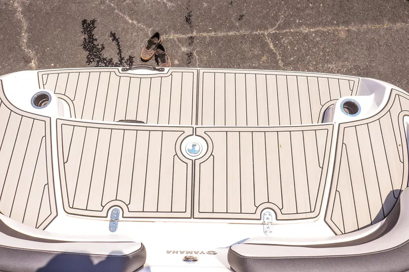 Slide: The Image of 2025 Yamaha Boats AR195 swim platform with sleek design and cup holders. - 23