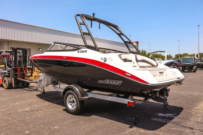 Slide: The Image of 2025 Yamaha Boats AR195 on trailer, parked outdoors, showcasing sleek design. - 3