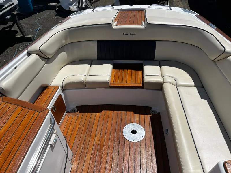 Slide: The Image of 2004 Chris-Craft Corsair 25 boat interior with elegant wood and cream seating. - 12