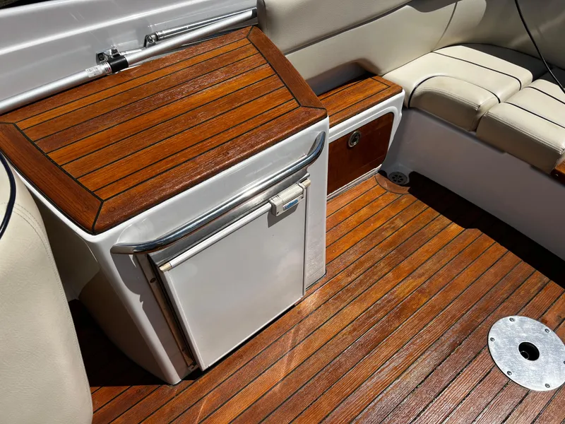 Slide: The Image of 2004 Chris-Craft Corsair 25 interior with wooden flooring and seating area. - 13