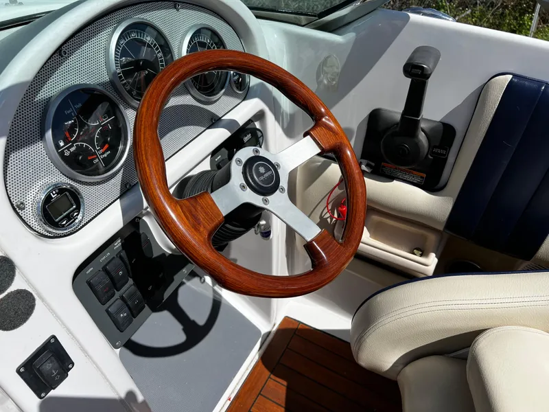 Slide: The Image of 2004 Chris-Craft Corsair 25 dashboard with wooden steering wheel and control panel. - 16