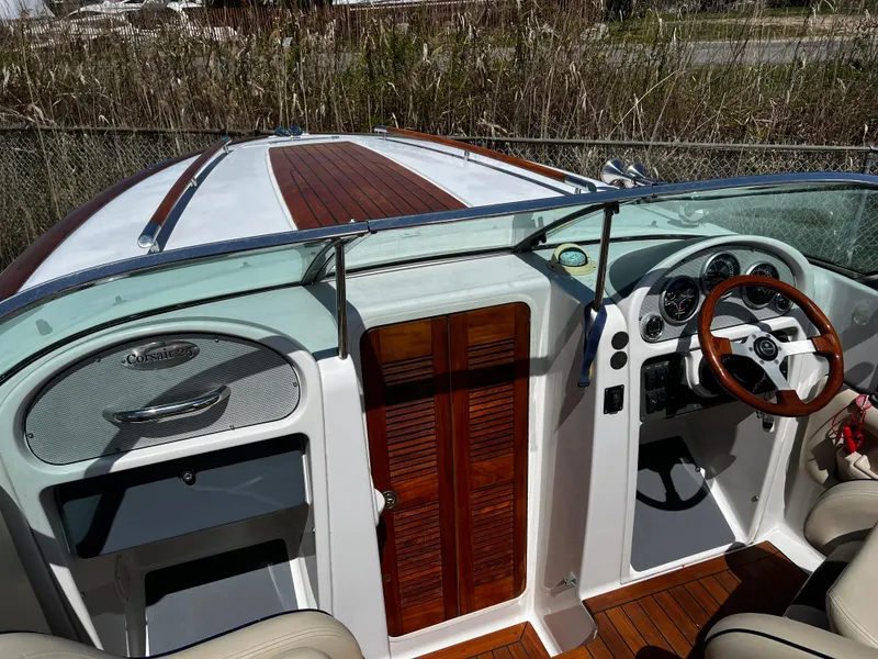 Slide: The Image of 2004 Chris-Craft Corsair 25 boat interior with wooden accents and steering wheel. - 8