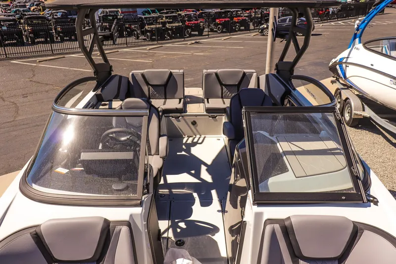 Slide: The Image of 2025 Yamaha Boats 255XD interior with seating and steering wheel, parked outdoors. - 19