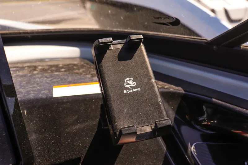 Slide: The Image of Phone holder on 2025 Yamaha Boats 255XD dashboard, featuring AquaAmp branding. - 23