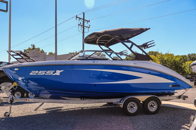 Slide: The Image of 2025 Yamaha Boats 255XD, blue and white, on a trailer in a sunny outdoor setting. - 4