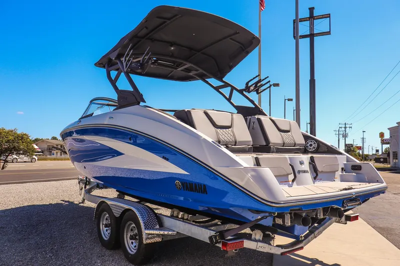 Slide: The Image of 2025 Yamaha Boats 255XD on trailer, blue and white design, parked outdoors. - 5