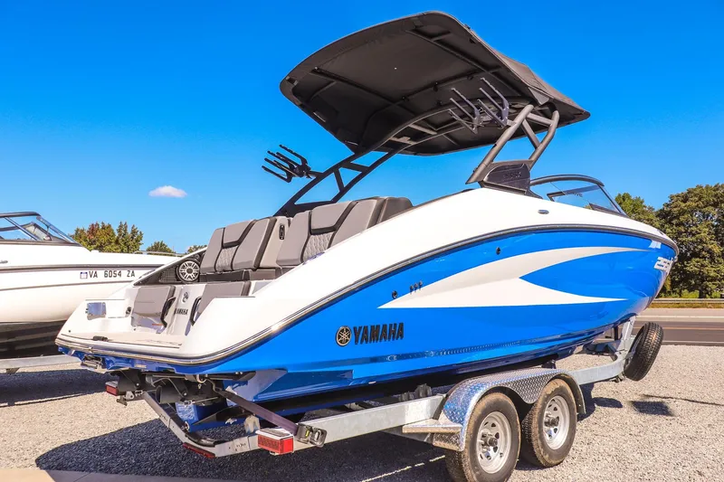 Slide: The Image of 2025 Yamaha Boats 255XD on trailer, blue and white design, parked outdoors. - 7