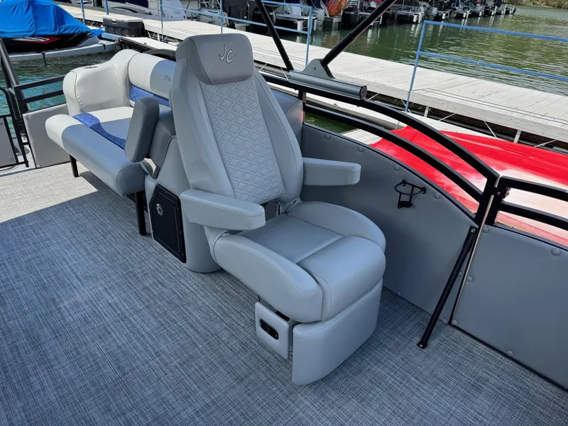 Slide: The Image of Luxury seating on 2025 JC Neptoon Sport 23TT DSL pontoon boat, docked by the water. - 11