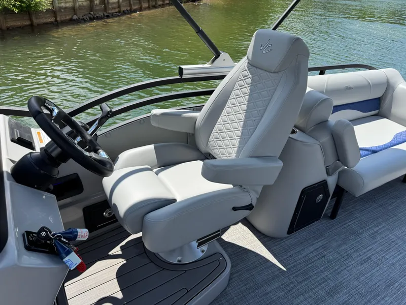 Slide: The Image of Captain's chair on 2025 JC Neptoon Sport 23TT DSL pontoon boat, with sleek design and water backdrop. - 14