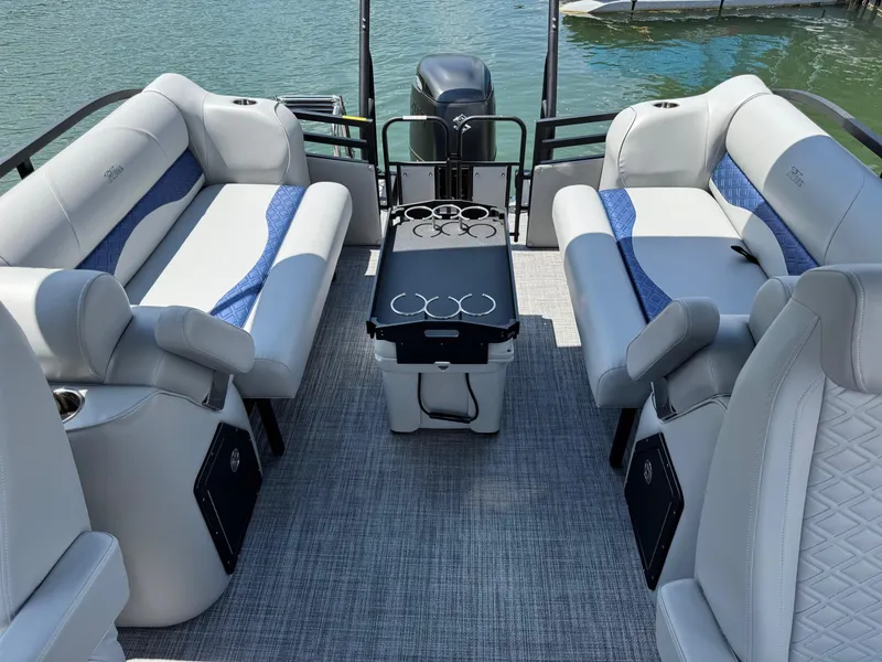 Slide: The Image of 2025 JC Neptoon Sport 23TT DSL pontoon boat interior with plush seating and table on water. - 22