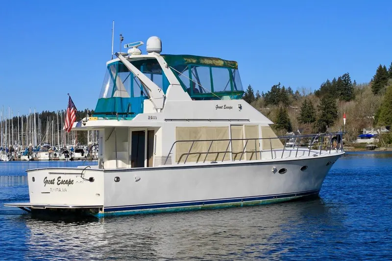 Slide: The Image of 1999 McKinna 47 Sedan yacht on a serene lake with clear blue skies. - 1