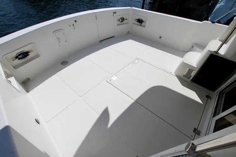 Slide: The Image of Spacious deck of a 1999 McKinna 47 Sedan yacht, featuring clean white surfaces. - 10