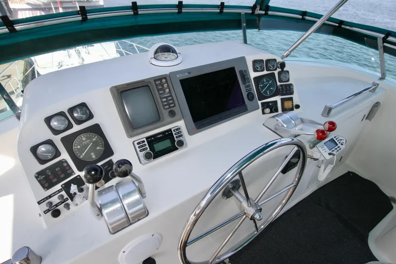 Slide: The Image of 1999 McKinna 47 Sedan yacht helm with navigation instruments and steering wheel. - 14