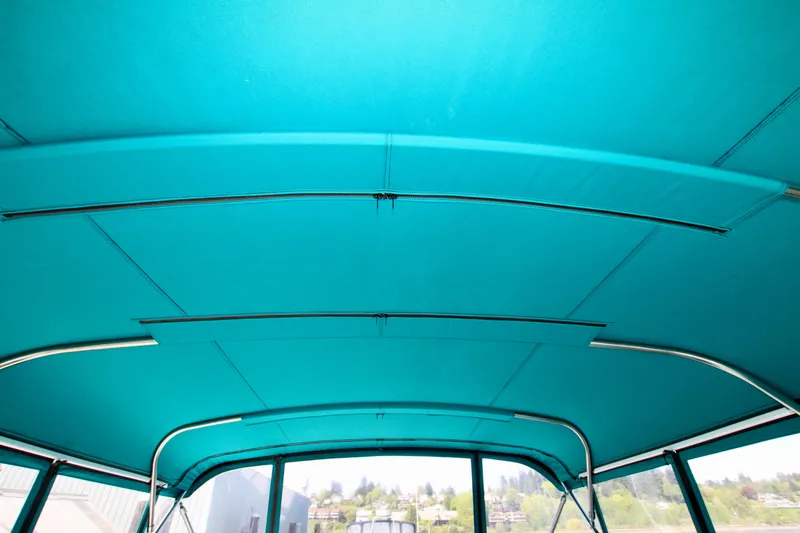 Slide: The Image of Interior view of a 1999 McKinna 47 Sedan boat with teal canopy. - 16