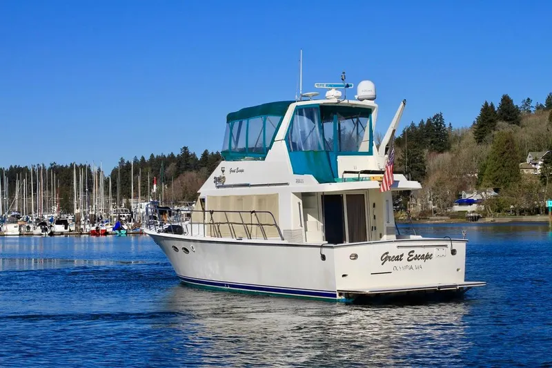 Slide: The Image of 1999 McKinna 47 Sedan yacht cruising in a marina with clear blue skies. - 2