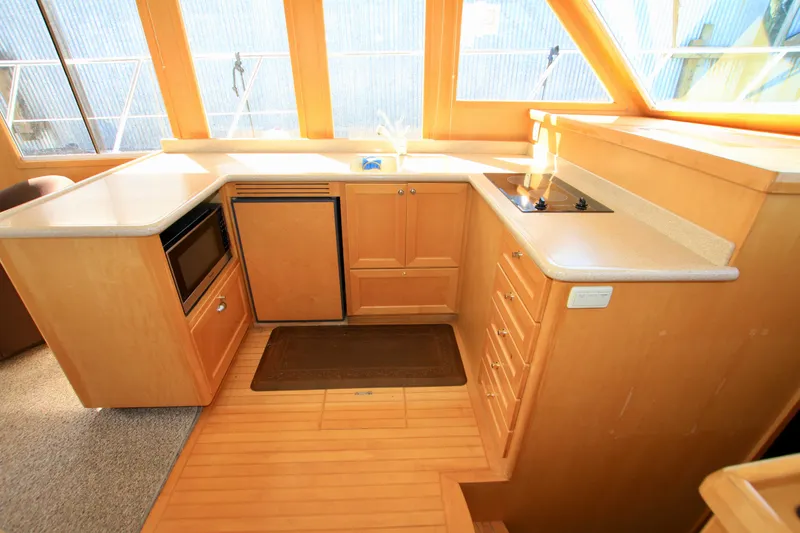 Slide: The Image of 1999 McKinna 47 Sedan yacht interior kitchen with wood cabinetry and modern appliances. - 26