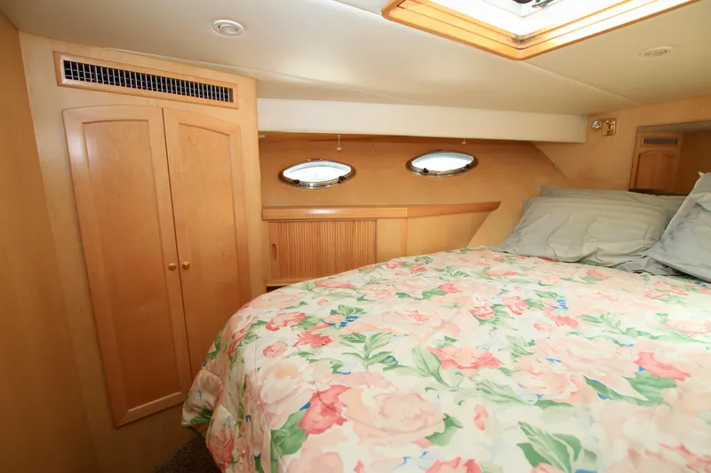 Slide: The Image of Cozy bedroom in 1999 McKinna 47 Sedan yacht with floral bedding and wooden cabinetry. - 32