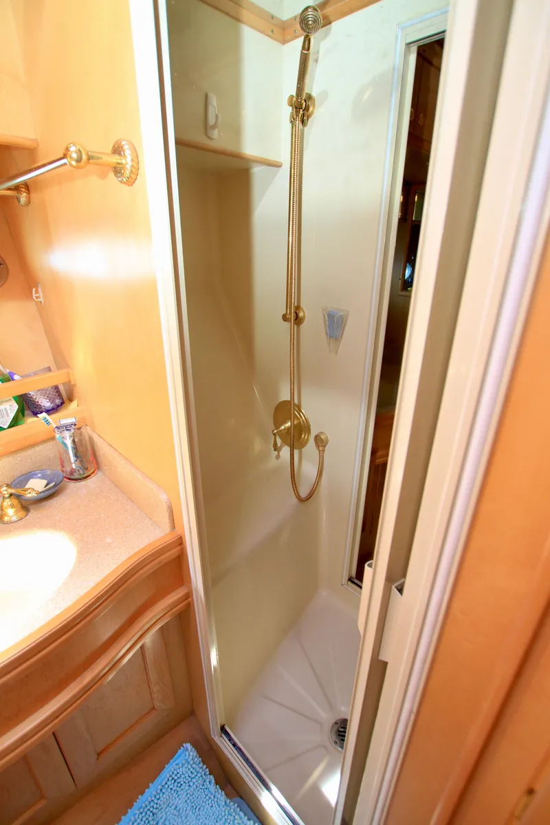 Slide: The Image of Shower area in 1999 McKinna 47 Sedan yacht, featuring gold fixtures and compact design. - 39