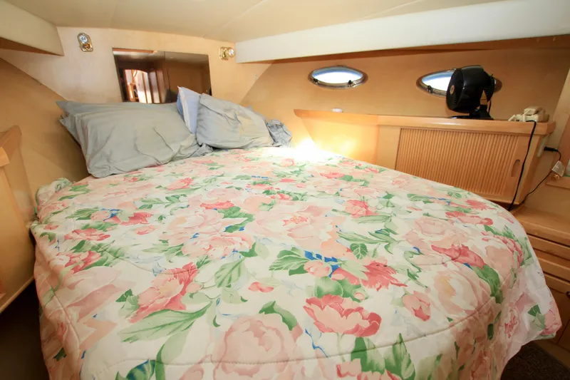 Slide: The Image of Cozy bedroom in 1999 McKinna 47 Sedan yacht with floral bedding and porthole windows. - 41