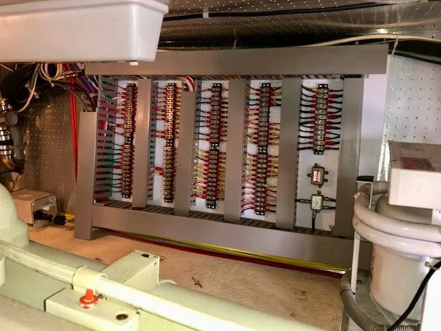 Slide: The Image of Electrical panel inside a 1999 McKinna 47 Sedan yacht, showcasing wiring and components. - 44