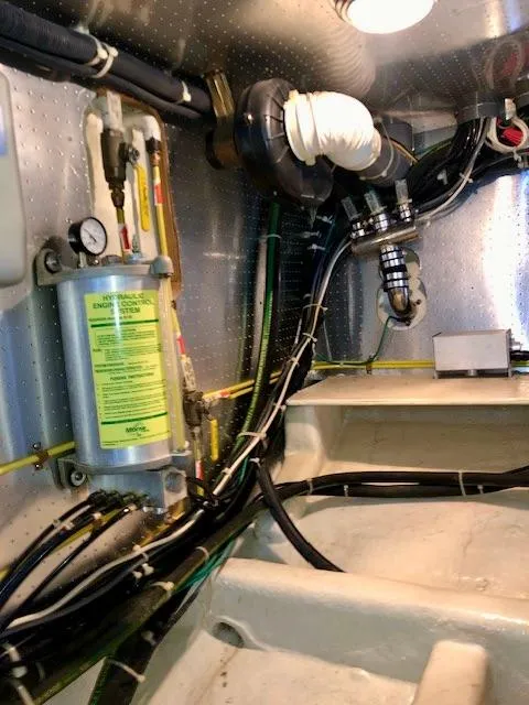 Slide: The Image of Engine room of a 1999 McKinna 47 Sedan yacht, showcasing mechanical components and wiring. - 46