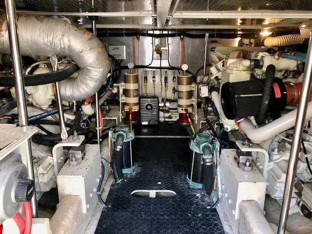 Slide: The Image of Engine room of a 1999 McKinna 47 Sedan yacht, showcasing mechanical components and systems. - 48