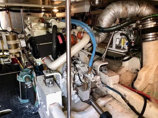 Slide: The Image of Engine room of a 1999 McKinna 47 Sedan yacht, showcasing complex machinery and piping. - 49