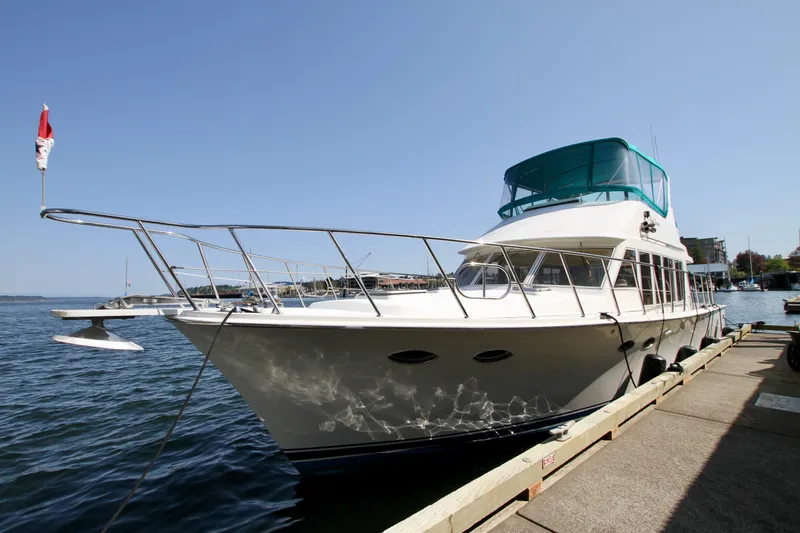 Slide: The Image of 1999 McKinna 47 Sedan yacht docked by the waterfront on a sunny day. - 5