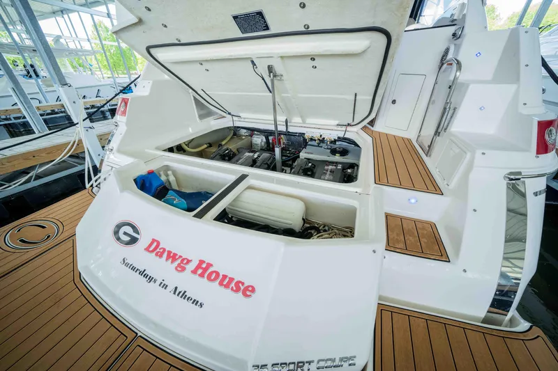 Slide: The Image of 2015 Regal 35 Sport Coupe boat with open engine compartment, "Dawg House" text on stern. - 15